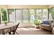 Sunroom with wooden floor, screened windows, wicker furniture, and views of the backyard at 9710 Iroquois Ct, Indianapolis, IN 46256