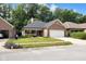 Beautiful brick home boasting a lush green lawn, a cozy front porch, and a convenient two-car garage with landscaping at 9735 Woodsong Ln, Indianapolis, IN 46229