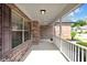 Inviting covered front porch with brick facade, white railing, and decorative shutters offering a warm welcome at 9735 Woodsong Ln, Indianapolis, IN 46229