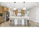 Bright kitchen features an island with seating, modern appliances, wood cabinetry, and stylish pendant lights at 9737 Oleander Dr, Fishers, IN 46250