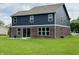 Back of the home featuring blue siding, brick, and a sliding glass door to the spacious backyard at 980 S Raylee Garden Dr, New Palestine, IN 46163