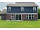 Back of the home featuring blue siding, brick, and a sliding glass door to the spacious backyard at 980 S Raylee Garden Dr, New Palestine, IN 46163