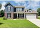 Charming two-story home featuring a brick and blue wood facade, with a well-manicured lawn at 980 S Raylee Garden Dr, New Palestine, IN 46163
