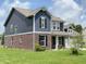 Charming two-story home featuring a brick and blue wood facade at 980 S Raylee Garden Dr, New Palestine, IN 46163