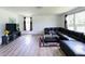Spacious living room with L-shaped couch, hardwood floors, and natural light exudes comfort at 980 S Raylee Garden Dr, New Palestine, IN 46163