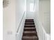 Carpeted staircase featuring white painted banisters and a light fixture at 980 S Raylee Garden Dr, New Palestine, IN 46163
