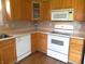 Functional kitchen with modern white appliances, stainless sink, wood cabinets and laminate flooring at 10178 Cornith Way, Avon, IN 46123