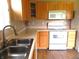 Functional kitchen with modern white appliances, stainless sink, wood cabinets and laminate flooring at 10178 Cornith Way, Avon, IN 46123