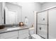 Bathroom with white cabinets, gray quartz countertops, and a glass shower with white tiles at 10262 Rieslaner Cir, Zionsville, IN 46077