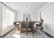 Stylish dining room features a wooden table with bar stools, an elegant chandelier, and natural light at 10262 Rieslaner Cir, Zionsville, IN 46077