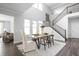 Bright dining area with modern table, chairs, and an open staircase at 10262 Rieslaner Cir, Zionsville, IN 46077