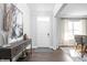 Welcoming foyer with wood floors, a console table, artwork, and a view of the dining area at 10262 Rieslaner Cir, Zionsville, IN 46077