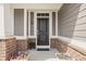 Close-up of a home's entryway, showcasing a black door, stylish accents, and planters with colorful flowers at 10262 Rieslaner Cir, Zionsville, IN 46077