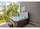 Inviting backyard hot tub with a natural wood surround and stone patio, perfect for relaxation at 10262 Rieslaner Cir, Zionsville, IN 46077