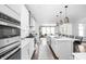 Stylish kitchen features white cabinets, stainless steel appliances, an island with seating, and hardwood floors at 10262 Rieslaner Cir, Zionsville, IN 46077
