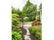 Picturesque backyard with a stone pathway leading to a pergola, pool area, and lush landscaping, creating a serene outdoor space at 1037 Deer Lake Dr, Carmel, IN 46032