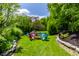 Charming backyard with a fire pit, colorful Adirondack chairs, and lush landscaping under a sunny sky at 1037 Deer Lake Dr, Carmel, IN 46032