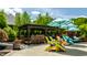 Outdoor kitchen with stone bar, cozy seating under umbrellas, and lush landscaping creates an inviting backyard oasis at 1037 Deer Lake Dr, Carmel, IN 46032