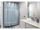 Bathroom featuring a shower with a blue curtain, white vanity, and a well-lit mirror; a clean and functional space at 1037 Deer Lake Dr, Carmel, IN 46032