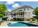 Elegant home exterior with a charming screened-in porch overlooking a sparkling pool and well-manicured backyard at 1037 Deer Lake Dr, Carmel, IN 46032