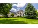 Expansive front lawn view of an elegant brick home showcasing lush landscaping and mature trees at 1037 Deer Lake Dr, Carmel, IN 46032
