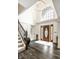 Grand foyer with hardwood floors, staircase, a chandelier, and a large arched window at 1037 Deer Lake Dr, Carmel, IN 46032