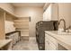 Bright laundry room featuring gray tile flooring, washer/dryer, and a built-in shelving and laundry basket storage at 1037 Deer Lake Dr, Carmel, IN 46032
