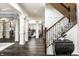 Open-concept living area with hardwood floors, staircase, and decorative pillars at 1037 Deer Lake Dr, Carmel, IN 46032