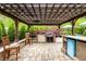 Outdoor kitchen under pergola features a built-in grill and bar, perfect for outdoor entertaining at 1037 Deer Lake Dr, Carmel, IN 46032