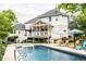 Stunning backyard with a luxurious pool, comfortable lounge chairs, and a view of the home's architecture and outdoor spaces at 1037 Deer Lake Dr, Carmel, IN 46032