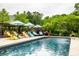 Inviting pool area with colorful Adirondack chairs, umbrellas, and a pergola, perfect for relaxation and outdoor enjoyment at 1037 Deer Lake Dr, Carmel, IN 46032