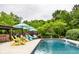 Backyard pool features lounge seating and a beautifully landscaped patio, perfect for relaxation and outdoor fun at 1037 Deer Lake Dr, Carmel, IN 46032