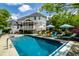 Backyard pool area with ample seating and a view of the lush landscaping and surrounding property at 1037 Deer Lake Dr, Carmel, IN 46032