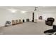 Open basement with a projector, plenty of seating, shelving and a neutral color palette at 10587 Proposal Pointe Way, Fishers, IN 46040