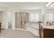 Well-lit bathroom featuring a soaking tub, shower with gold trim and tile floors at 10587 Proposal Pointe Way, Fishers, IN 46040