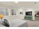Cozy bedroom features two windows, a bed, a green cabinet with a TV, and easy access to basement at 10587 Proposal Pointe Way, Fishers, IN 46040