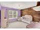 A charming Bedroom with purple walls, a wooden accent wall, and a crib at 10587 Proposal Pointe Way, Fishers, IN 46040