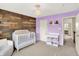 A delightful Bedroom with a crib, a changing table, and a rustic wooden accent wall at 10587 Proposal Pointe Way, Fishers, IN 46040