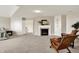 Cozy bedroom featuring a fireplace, two comfy chairs, soft carpet, and a neutral color palette at 10587 Proposal Pointe Way, Fishers, IN 46040