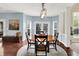 Sun-filled dining area features a round wood table, modern light fixture, and neutral color palette at 10587 Proposal Pointe Way, Fishers, IN 46040