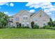 Charming two-story brick home with a lush green lawn, mature trees, and blooming hydrangeas at 10587 Proposal Pointe Way, Fishers, IN 46040