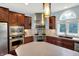 This kitchen features stainless steel appliances, stone countertops, and custom wood cabinets at 10587 Proposal Pointe Way, Fishers, IN 46040