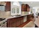 Bright kitchen features stainless steel appliances, light countertops, and dark wood cabinets at 10587 Proposal Pointe Way, Fishers, IN 46040