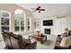 Bright living room with large windows, a fireplace, custom built-ins, and comfortable seating at 10587 Proposal Pointe Way, Fishers, IN 46040
