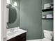 Charming powder room with stylish round mirror, decor shelving, and updated fixtures at 10587 Proposal Pointe Way, Fishers, IN 46040