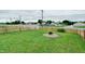 Spacious backyard with a fire pit surrounded by landscaping and a wooden fence at 1059 Wild Ivy Trl, Franklin, IN 46131