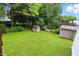 Expansive backyard with well-maintained lawn, mature trees, and storage sheds, offering serene outdoor space at 1103 Rosengarten Dr, Greenwood, IN 46142
