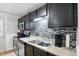 The kitchen features stainless steel appliances, black cabinets, and a stylish backsplash at 1103 Rosengarten Dr, Greenwood, IN 46142