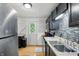 Kitchen features stainless steel appliances, black cabinets, and a view to the back door at 1103 Rosengarten Dr, Greenwood, IN 46142