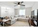 Bright living room featuring a large comfortable sofa, ceiling fan, and view to dining and kitchen at 1103 Rosengarten Dr, Greenwood, IN 46142